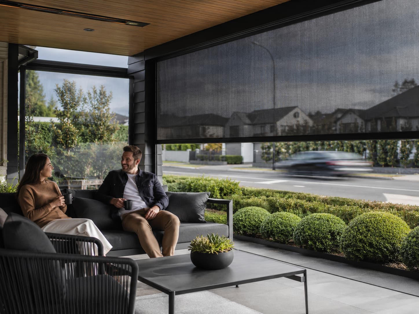 Guided outdoor roller screens around a hospitality terrace