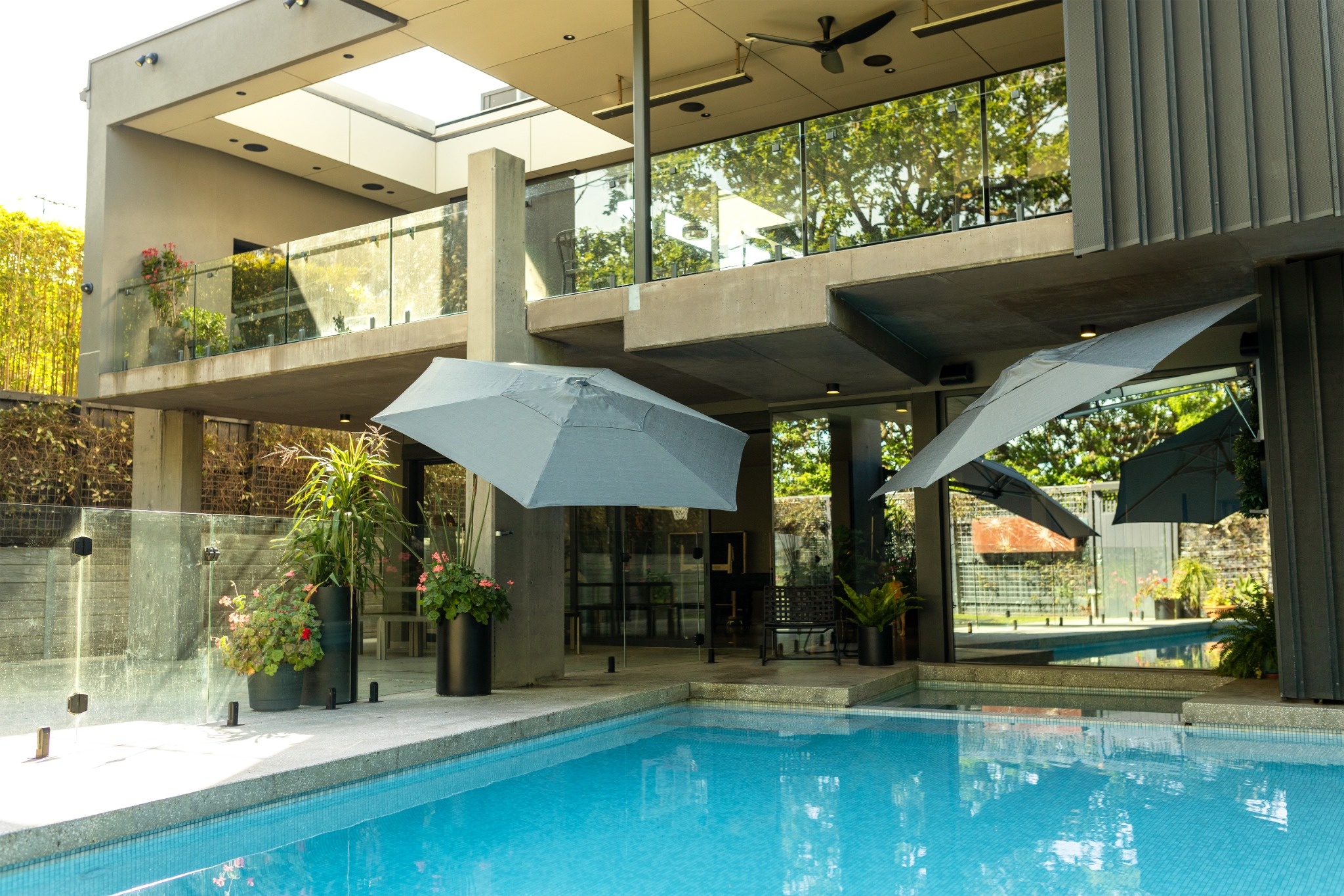 Shadowspec RETREAT wall-mounted umbrella shading a poolside terrace