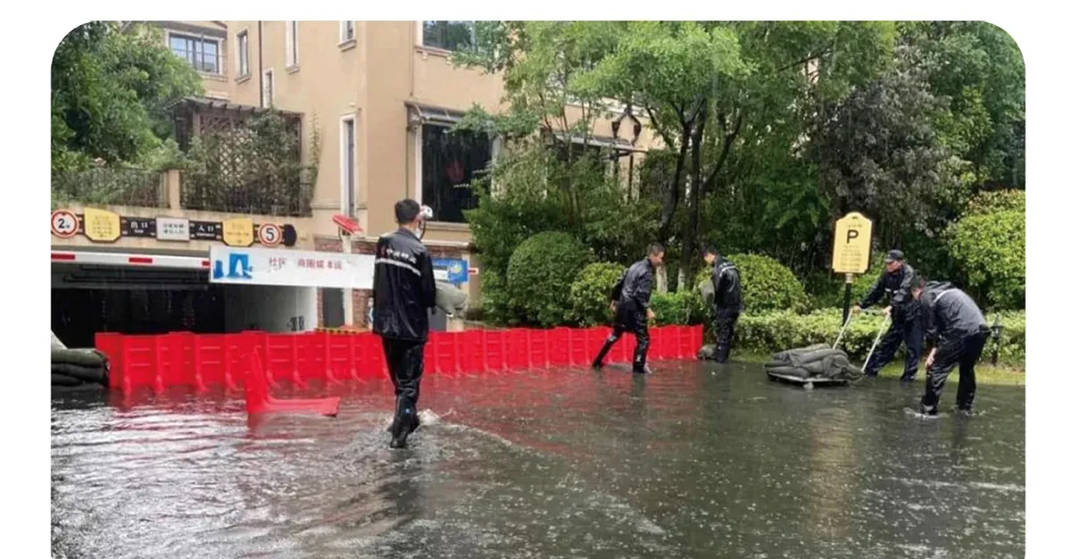 Modular red flood barriers deployed around a flooded urban property