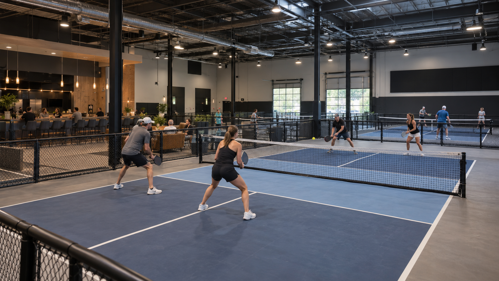 Modern indoor pickleball club with multiple courts and lounge area