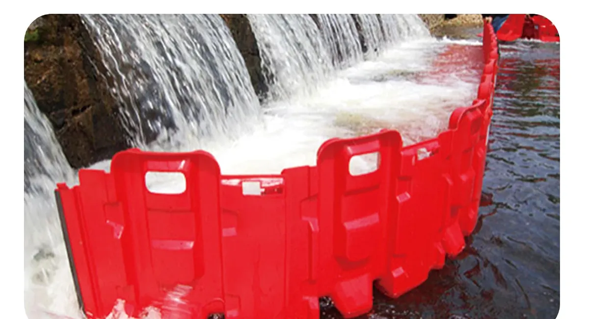 Red modular plastic flood barriers deployed against moving water